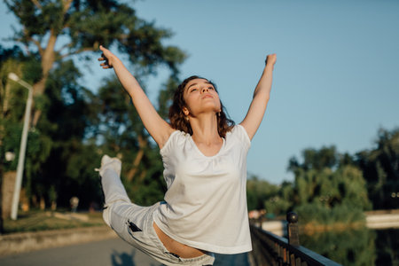 Outdoor Wellness Teenager Stretching and Exercising. a young girl doing exercises in the parkの写真素材