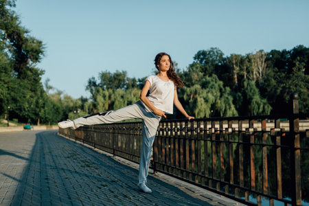 Teenage Athlete Outdoor Fitness and Physical Activity. a young girl doing exercises in the park. Teen Spirit Physical Fitness and Sporting Outdoorsの写真素材