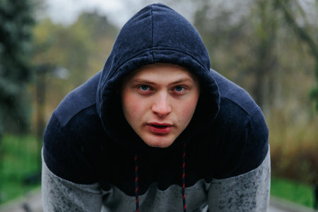 Young Sportsman in Action A Dynamic Outdoor Portrait. A dynamic shot of a sporting guy in action, as he runs across a scenic outdoor landscape with a look of intense focus on his face.の写真素材
