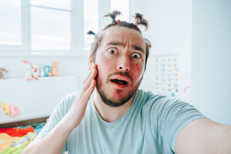 A man with makeup is making a humorous face while having fun at home. Staring in Wonder with Make Upの写真素材