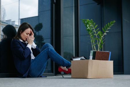 A Womans Struggle with Unemployment Sitting Down, Clutching Personal Things. Empty Chair, Broken Dreams Loss Work and Unemployment Strugglesの写真素材