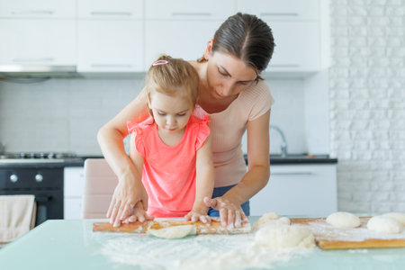 A slice of domestic life a mother and daughter team up in the kitchen, preparing dough with smiles...