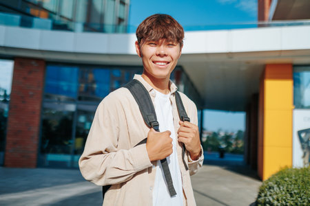 A delightful scene captures the essence of a bright young Asian Korean student boy looking at camera, radiating happiness, as he smiles warmly into the cameras lens.の写真素材