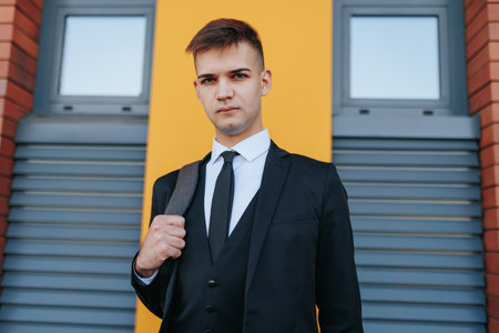 Amidst the hustle and bustle of the business world, a young Caucasian American man in a business suit showcases the essence of a modern professional.の写真素材