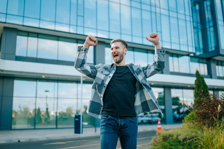 In the heart of the city, a bearded Caucasian man revels in the sweet taste of victory. His laughter echoes through the streets as he savors his achievement, portraying genuine happiness.の写真素材