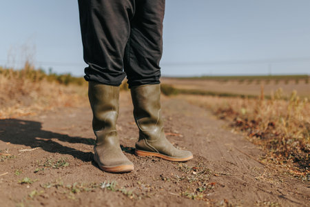 Capturing the Essence of Farming A Close Up of Farmer legs Work Boots. Ground Level Glimpse of Rural Abundance Close Up on Farmer feet Rubber Bootsの写真素材