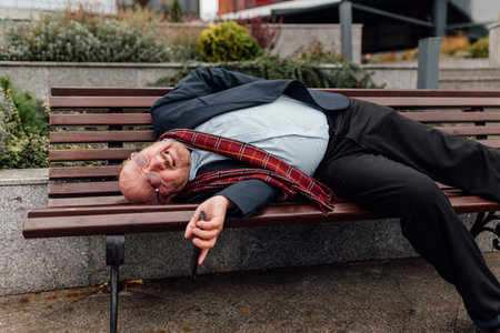 Elderly Health Alert Anxious senior bearded man urgently calls for help, lose consciousness, disturbed by sudden chest pain possibly linked to a heart attack in an outdoor city environment.の写真素材