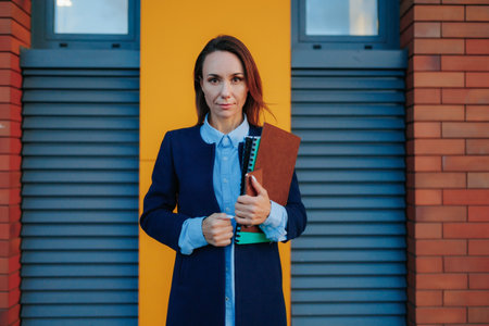 City Siren A Confident Hispanic Businesswoman, Showcasing Success and Style on the Urban Streets. of a Successful Businesswoman looking at camera Charisma and Elegance, background brick wallの写真素材