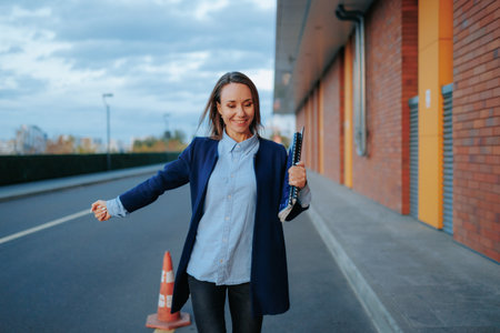 City Charm A Content and Glad Young Woman walk in Business Attire, Showcasing the Joy of Professional Triumphs. Downtown, A Happy Young Woman, a Portrait of Success, Strolling with Confidenceの写真素材