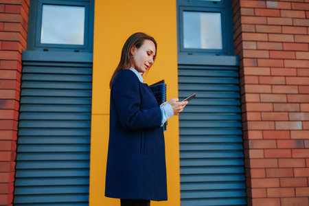 Tech Savvy Professional An American Businesswoman Walks with Purpose, Troubled Yet Focused, Holding Her Smartphone as She Tackles Business Matters.の写真素材