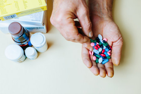 Unrecognizable close up handful of pills in his hand, other hand takes one piper from common pile. Prescribed treatment must be performed. Dependence on pills. Vitamins and minerals.の写真素材