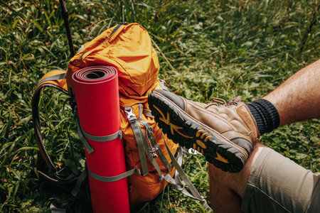 the foot of a tourist man next to his backpack, outdoor travel and hiking, on a solo trip to connect with natures tranquility.の写真素材