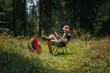 Escape into the realm of imagination as a bearded man, surrounded by natures wonders, indulges in the timeless pleasure of reading. With a book in hand and a backpack as a companion,の写真素材
