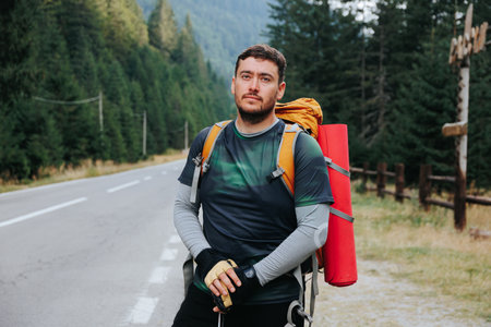 Join a Latino hiker man on an invigorating trek along a picturesque highway, embodying the essence of a healthy lifestyle and the joy of outdoor exploration.の写真素材