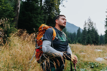 A spirited Caucasian hiker, embodying the essence of a healthy lifestyle, journeys through the woodland, rucksack firmly in place on an exploration trip into natures embrace.の写真素材