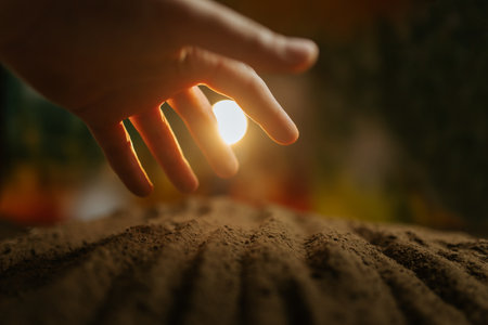A farmers hands work the soil, with selective focus on the palms and a beautiful garden in the backgroundの写真素材
