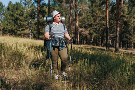 Embark on a journey of empowered strides with a plus size woman conquering the great outdoors in a triumphant hiking adventure. Experience the transformative power of her solo trek,の写真素材