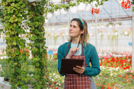 business woman an agronomist in the flower business is engaged in a hobby. The florist works with notebook. Entrepreneur notes information about plants. copy spaceの写真素材
