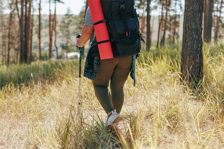 Experience the magic of slow motion movement in this enchanting , featuring the back view of a plus size woman on a trekking trip, showcasing the elegance and determination of a solo hiker.の写真素材