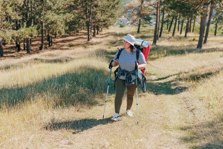Witness the harmony between an active lifestyle and the great outdoors as a plus-size woman takes you on a journey of hiking and exploration, celebrating the beauty of her solo trek.の写真素材
