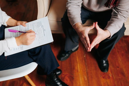 Unrecognizable woman hand writes down with pen on paper everything that client says, hands of man close up. Woman and man sit in office, hands in wrinkles, young hands.の写真素材
