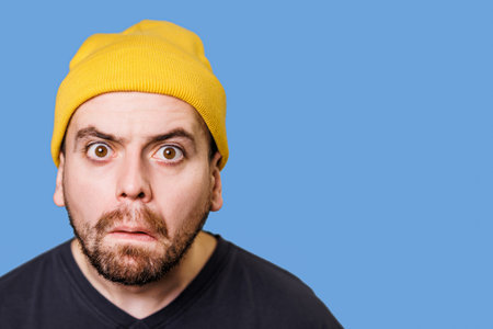A male with an overwhelmed expression, his face showing worry and anxiety, portrait studio shot with the subject looking at the camera. Perplexed and Bewildered A Studio Shot of a Males Emotionsの写真素材