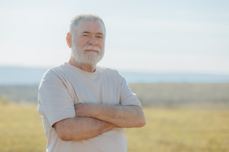 Through the lens of outdoor photography, the essence of a senior mans grace and charm is magnificently portrayed, his distinguished beard adding to his allure.の写真素材