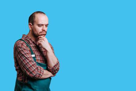 studio portrait of a handsome bearded engineer builder captures a sense of contemplation and introspection thanks to his pensive expression and thoughtful face. copy spaceの写真素材