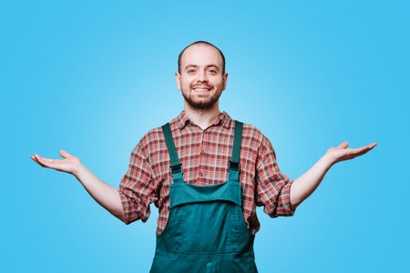 The male dressed in a coverall and with an expression of pure gladness on his face, spreads his arms wide in a gesture of positivity and delight, radiating a sense of merriment and cheer. copy space,の写真素材