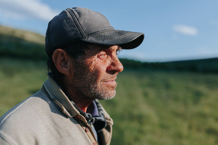 The essence of rural tradition is captured in this portrait of an elderly man, a shepherd farmer by trade, standing amidst the fields with a sense of quiet dignity and purpose.の写真素材