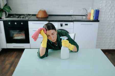 Unhappy Woman in Yellow Gloves, Seated at Kitchen Table