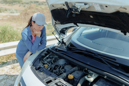 Frustrated Young Brunette Near Her Car with a Damaged Engineの写真素材