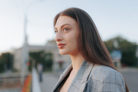 Serene Brunette Woman Close-Up Portrait with Sunset Glowの写真素材