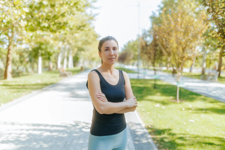 A young white woman relaxing after her workout in the park under the warm sun.の写真素材