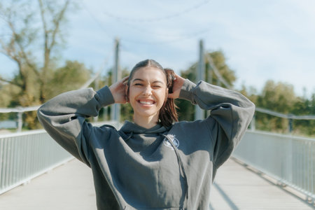 A teen woman wearing a grey hoodie is smiling and posing for a pictureの写真素材
