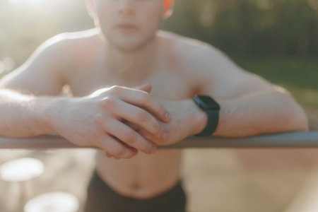 Fit Young Man with Naked Torso Relaxing After Outdoor Exerciseの写真素材