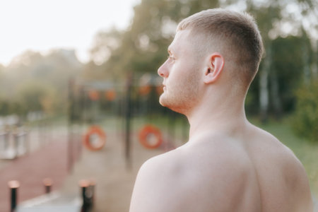 Rear view of young male athlete with naked torso during outdoor workout.