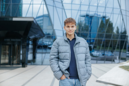Teenage Boy in Front of Contemporary Architecture with Casual Styleの写真素材