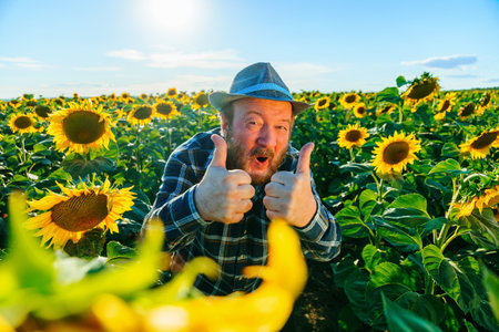 amazed joyful senior rural farmer man show thumbs up and wearing countryside hatの写真素材