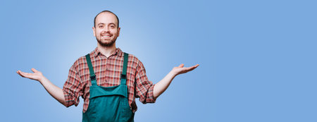 Cheerful farmer expresses joy with open arms against a blue backgroundの写真素材