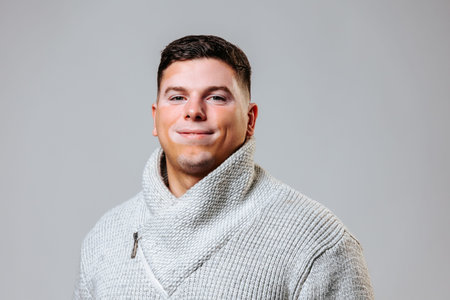 Male model with vitiligo showcasing confidence in a neutral backgroundの写真素材