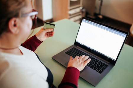 Online shopping experience with credit card on laptop at homeの写真素材