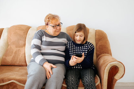 Grandmother and granddaughter enjoying time together on the sofa