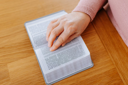 Reading a book on a wooden table during a quiet afternoon at home