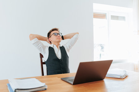 Young professional relaxes while working at home office during daytimeの写真素材