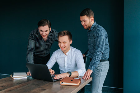 Young entrepreneurs collaborating on a business idea in a modern office environment with laptopsの写真素材
