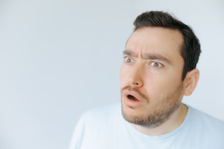 Man expressing surprise in a minimalist indoor environment during daytimeの写真素材