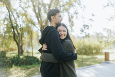 Romantic Autumn Reunion as Couple Embraces with Happiness in the Parkの写真素材