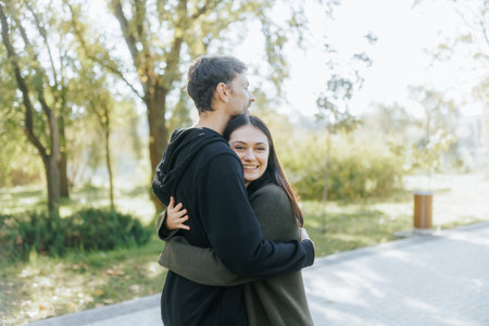 Happy Couple Embraces in an Autumn Park, Smiling with Joy and Loveの写真素材