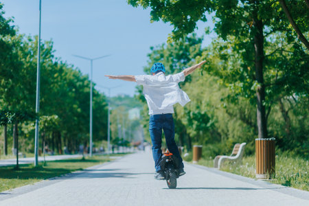 Man Riding Electric Unicycle in the Park With Arms Wide Openの写真素材